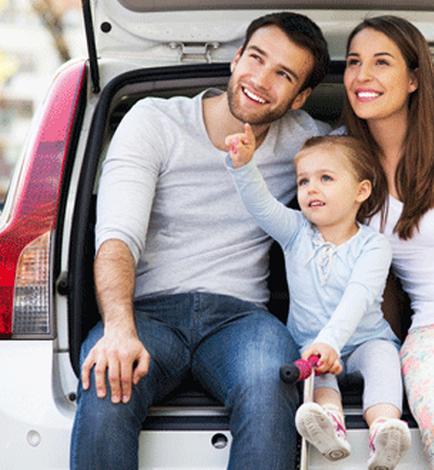 Family sitting on tailgate of car